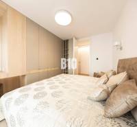 Schlafzimmer in einer 3-Zimmer-Wohnung mit Stauraum und einem Bett mit gemusterten Textilien.