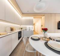 Eine stilvolle Küche in einer 3-Zimmer-Wohnung mit Holzboden und modernen Möbeln.