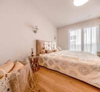 Schlafzimmer in einer 3-Zimmer-Wohnung mit einem Bett und einem Boden in Holzoptik.
