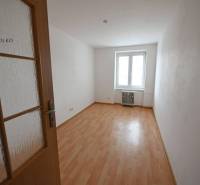 Ein Zimmer mit Holzboden in einer 2-Zimmer-Wohnung, ein heller Raum.