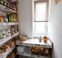 Speisekammer mit Regalen, Obst, Gemüse und Lebensmitteln in einer 2-Zimmer-Wohnung, Licht fällt durch das Fenster.