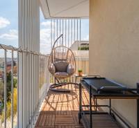 Der Balkon einer 3-Zimmer-Wohnung in Bratislava-Ružinov mit einer Schaukel und Blick auf die Stadt.