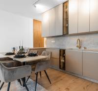 Küche in einer 3-Zimmer-Wohnung mit Esstisch und Boden in Holzoptik.