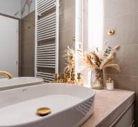 Badezimmer mit goldenen Details und Dekoration in einer 3-Zimmer-Wohnung.