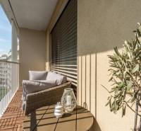 Ein Balkon in einer 3-Zimmer-Wohnung mit bequemen Sitzgelegenheiten, Aussicht und Dekorationen.