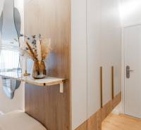 Eingangsflur mit Spiegel, Schrank und Dekoration in einer 3-Zimmer-Wohnung mit Holzboden.