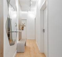 Ein heller Flur mit Spiegel, Bank und Boden in Holzoptik in einer 3-Zimmer-Wohnung.