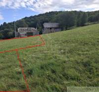 Grundstücke - Wohnen, Horný Tisovník. Grasfläche mit einem ländlichen Gebäude und einem bewaldeten Hügel im Hintergrund.
