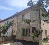 Ein Einfamilienhaus in Šiatorská Bukovinka, umgeben von Grün und Bäumen, mit einem schrägen Dach.