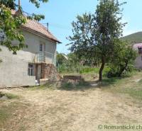 Ein Einfamilienhaus in Šiatorská Bukovinka mit Garten und Bäumen unter blauem Himmel.