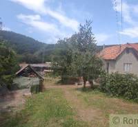 Ein Einfamilienhaus in Šiatorská Bukovinka mit Blick auf die Berge, ein Garten mit Bäumen und Weinreben.