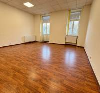 Büros mit Holzboden, heller Innenraum mit großen Fenstern.
