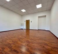 Ein Büro mit einem Boden in Holzoptik, weißen Wänden und einer abgehängten Decke.