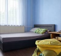 Kinderzimmer in einem Einfamilienhaus mit blauen Wänden und einem Boden in Holzoptik.