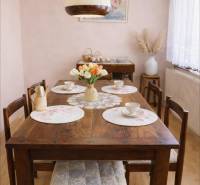 Esszimmer eines Einfamilienhauses mit einem Holztisch, dekoriert mit Blumen und Porzellan.