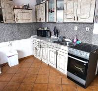 Küche mit Fliesen und Küchenzeile in einer 2-Zimmer-Wohnung.