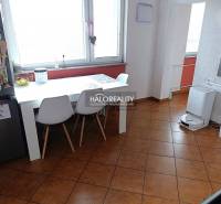 Esszimmer in einer 2-Zimmer-Wohnung mit weißem Tisch und braunem Boden.