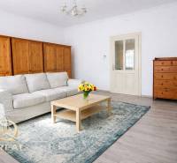Helles Wohnzimmer mit Sofa, Holzmöbeln und Boden in Holzoptik.