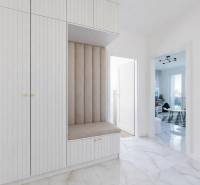 Eingangsbereich in einer 3-Zimmer-Wohnung mit abgestimmten Möbeln und Fliesen mit Marmormuster.