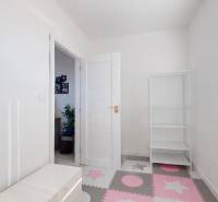 Kinderzimmer in einer 3-Zimmer-Wohnung mit weißen Wänden und einem bunten Boden.