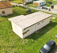 Ein Ferienhaus in Vojka nad Dunajom mit Flachdach und geparkten Autos auf der Rasenfläche.