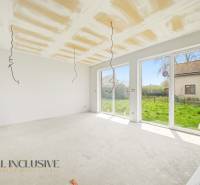 Das Innere der Hütte mit großen Fenstern und Blick auf den grünen Garten.