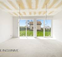 Ein geräumiger Raum in einer Hütte mit großen Fenstern und Blick auf den Garten.