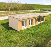 Eine Hütte in Vojka nad Dunajom auf einem grasbewachsenen Grundstück mit einer Straße im Hintergrund.