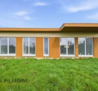 Ein Ferienhaus in Vojka nad Dunajom mit großen Fenstern und Flachdach, umgeben von einer Rasenfläche.