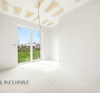 Ein leerer Innenraum einer Hütte mit einem großen Fenster und Blick in den Garten.