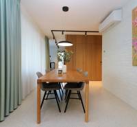 Esszimmer in einer 4-Zimmer-Wohnung mit Holztisch und dekorativer Wandmalerei.