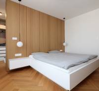 Schlafzimmer in einer 4-Zimmer-Wohnung mit Bett, Holzboden und Kleiderschrank.