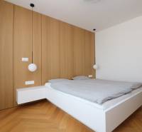 Schlafzimmer mit Hängeleuchten und Holzboden in einer 4-Zimmer-Wohnung.