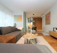 Stilvolles Wohnzimmer in einer 4-Zimmer-Wohnung mit Holzboden und Kunstgemälden.