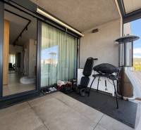 Balkon einer 4-Zimmer-Wohnung mit Grill, Stuhl und Blick auf Dúbravka.