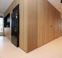 Küche in einer 4-Zimmer-Wohnung mit Holzdekor, einem schwarzen Kühlschrank und weißen Fliesen.