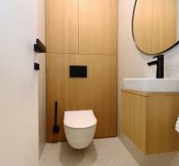 Toilette mit Holzboden und modernem Waschbecken in einer 4-Zimmer-Wohnung.