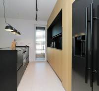Küche in einer 4-Zimmer-Wohnung mit schwarzer Küchenzeile und Holzschränken.