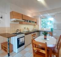 Küche mit Küchenzeile und Esstisch in einer 2-Zimmer-Wohnung.