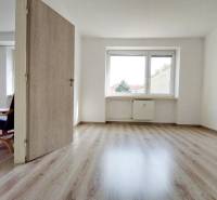 Innenraum einer 2-Zimmer-Wohnung mit Holzboden und hellen Wänden.