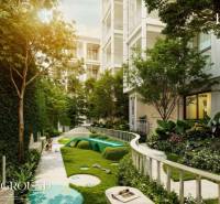 Außenbereich eines Wohnbaus in Phuket mit einem von Grün umgebenen Kinderspielplatz.