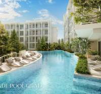 Ein Pool mit Liegestühlen, umgeben von im Bau befindlichen Wohngebäuden in Phuket.