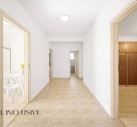 Der Flur in einem Einfamilienhaus mit Türen zu den Zimmern und Fliesen auf dem Boden.