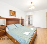 Schlafzimmer in einem Einfamilienhaus mit großem Bett, Schrank und Boden mit Holzdekor.