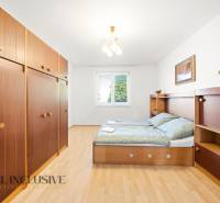 Schlafzimmer in einem Einfamilienhaus mit Holzboden, Stauraum und Bett.