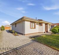 Ein Einfamilienhaus in Kútniky mit einem gepflasterten Gehweg und einem gepflegten Garten.