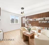 Wohnzimmer in einem Einfamilienhaus mit weißen Sesseln und einem Boden in Holzoptik.