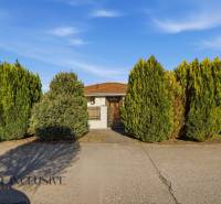Ein Einfamilienhaus in Kútniky, umgeben von gepflegten Bäumen, mit einem schönen Vorgarten.
