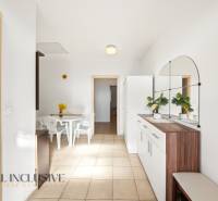 Innenraum eines Einfamilienhauses mit einem weißen Tisch und Stühlen, mit einem großen Spiegel an der Wand.