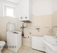 Badezimmer in einem Einfamilienhaus mit Speicher, Waschmaschine und Waschbecken.